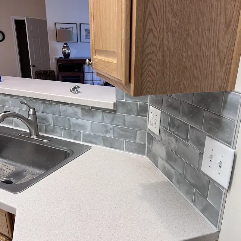 Kitchen counter sink with gray subway tile backsplash