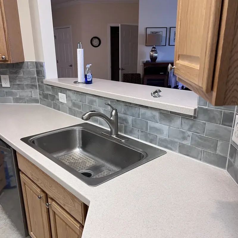 Kitchen sink countertop with gray tile backsplash