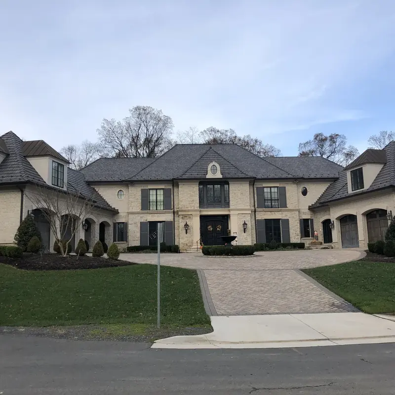 Large luxury stone home exterior with circular driveway