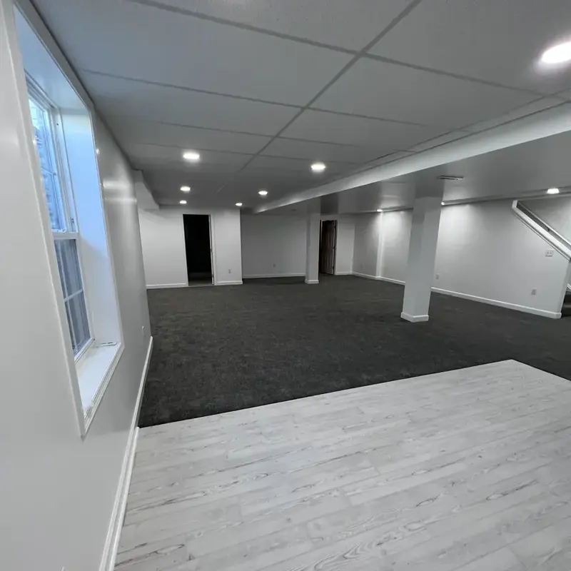 Finished basement transitioning between carpet and laminate flooring