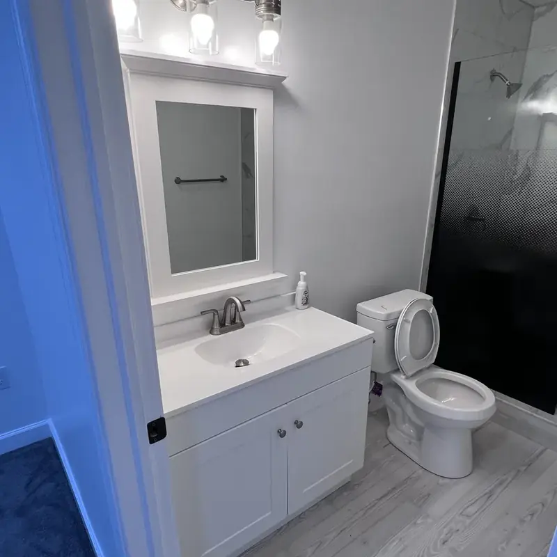 White bathroom vanity with mirror and toilet