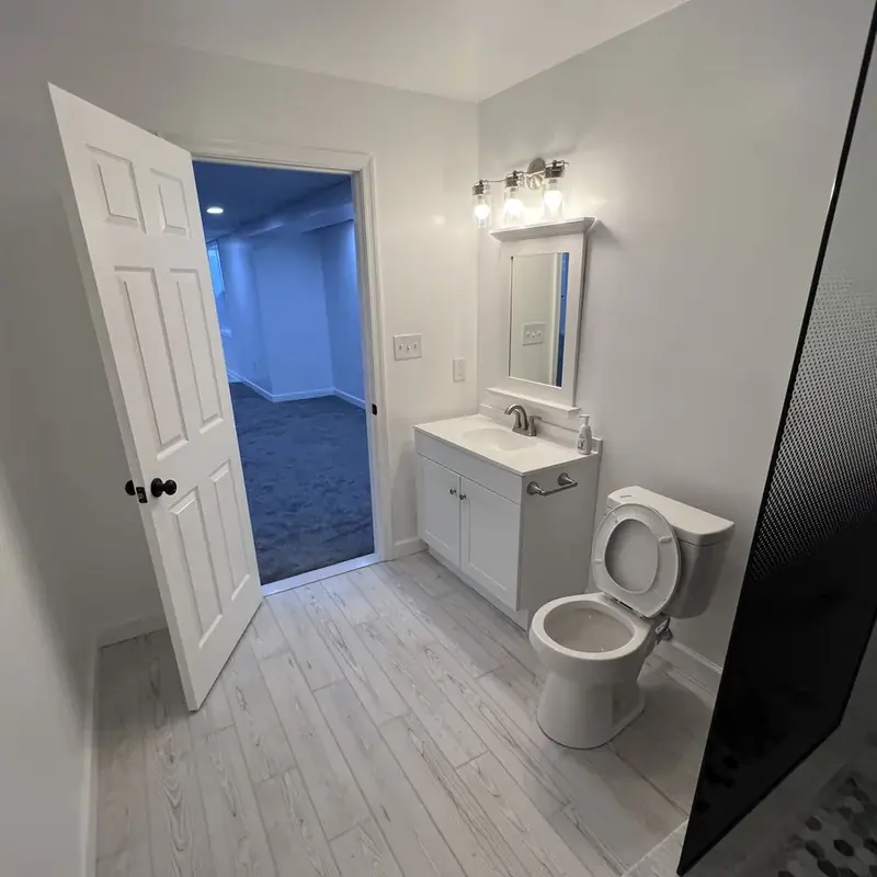 Bathroom vanity, mirror, and toilet near doorway