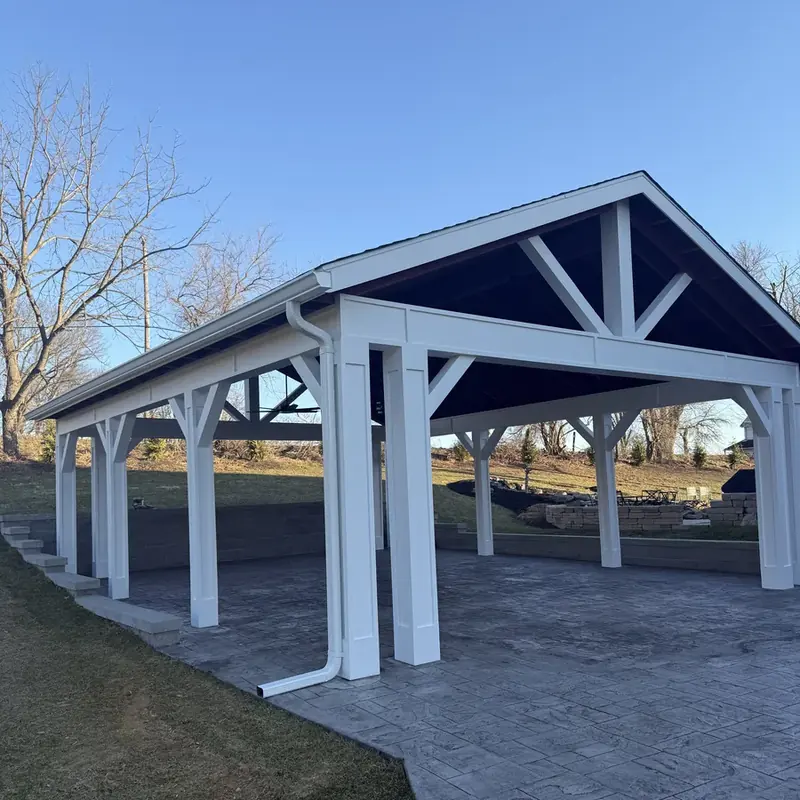 Outdoor pavilion with white posts and stamped concrete patio