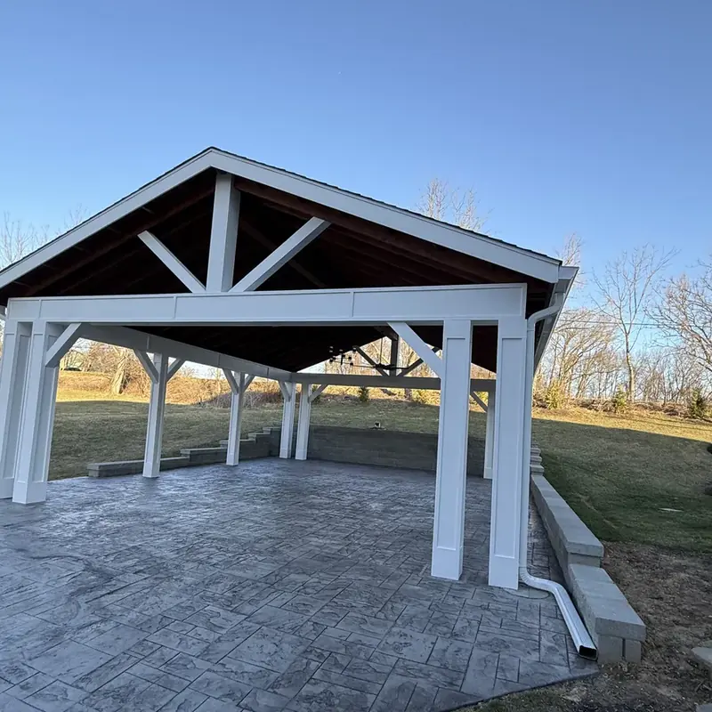 Outdoor pavilion with stamped concrete and stone retaining wall