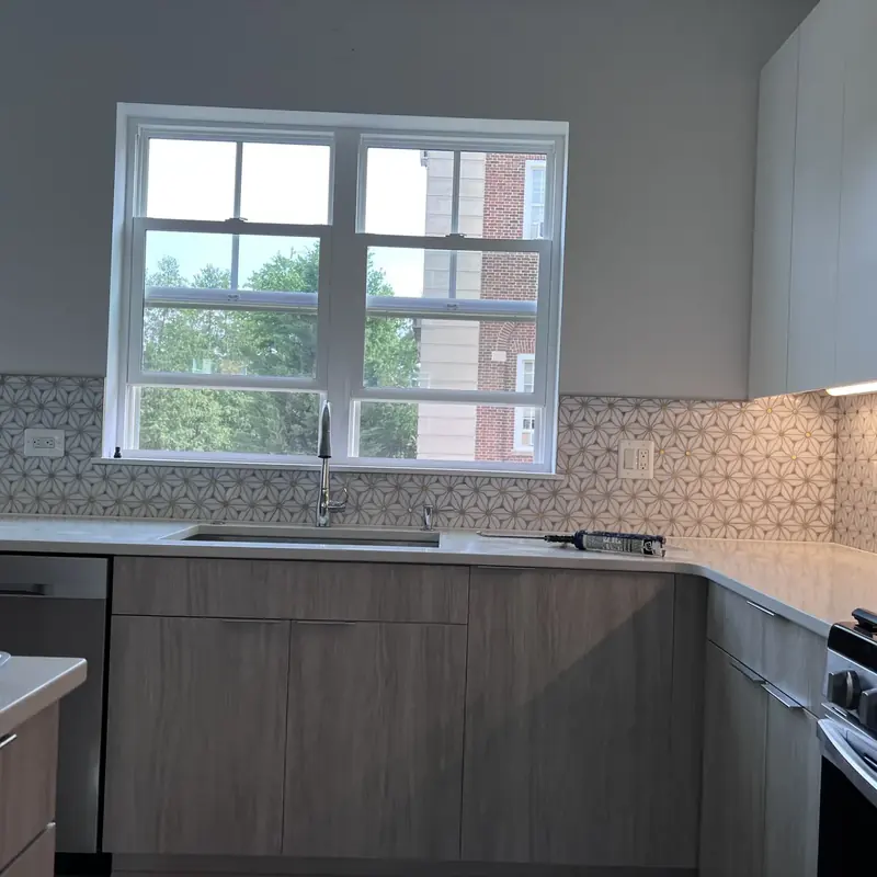 Modern kitchen with gray cabinets, white counters, gas range