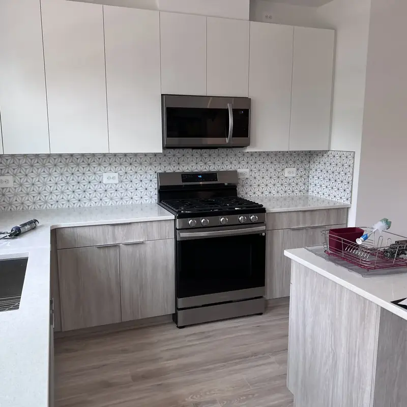 modern kitchen with stainless gas range and gray cabinets