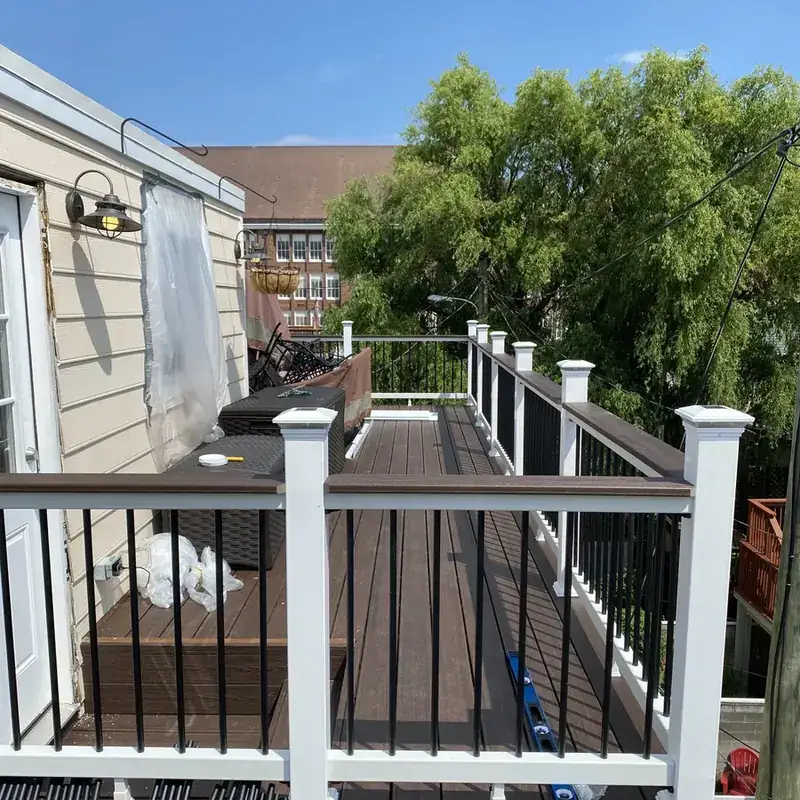 rooftop composite deck with white railings and grill