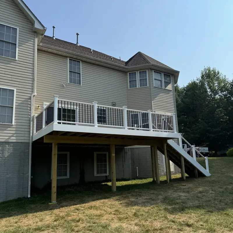 Elevated white-railing deck attached to vinyl-sided home