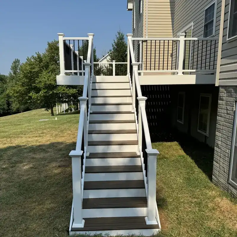 White-railed deck stairs leading down to lawn