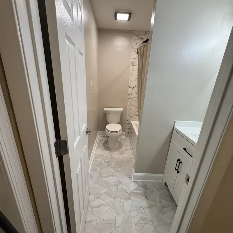 Small bathroom with toilet, vanity, marble flooring