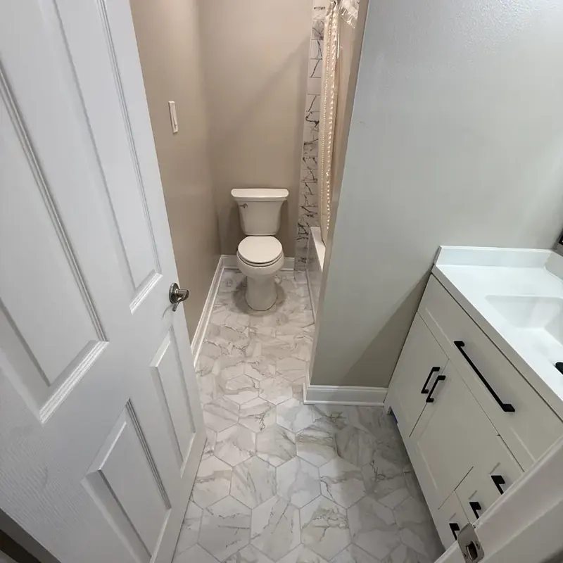 Bathroom view with toilet, marble floor, white vanity