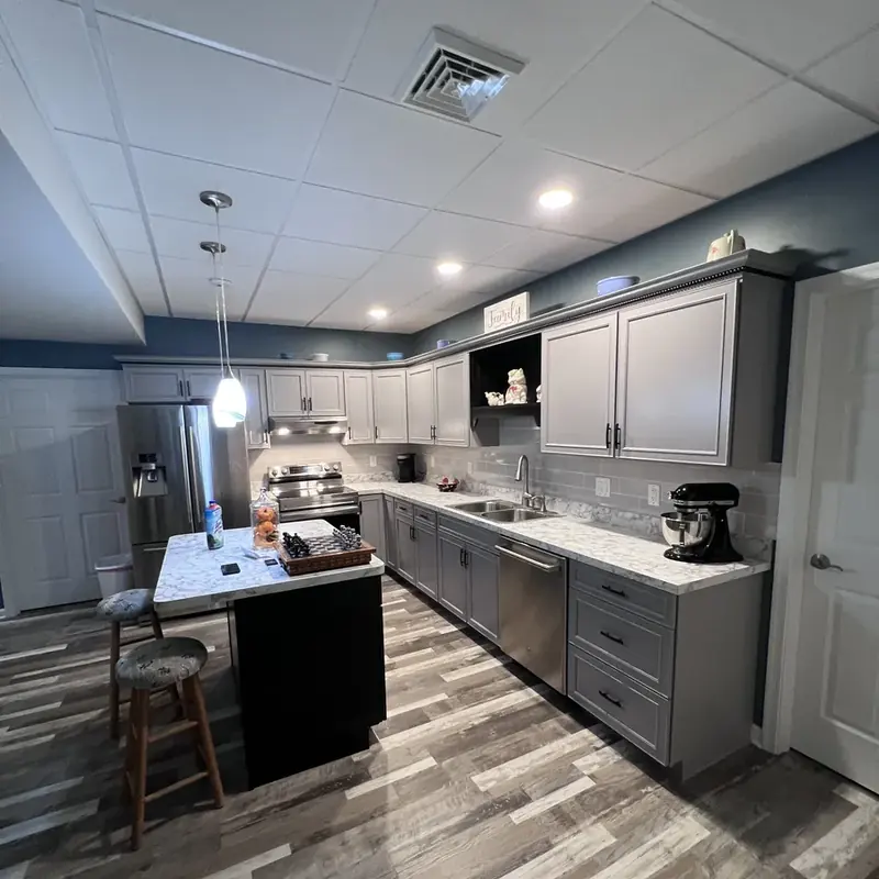 Basement kitchenette with gray cabinets and island