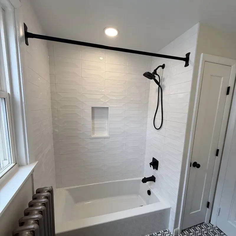 white tile tub shower with black fixtures