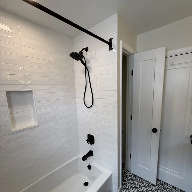 white subway tile shower with black fixtures