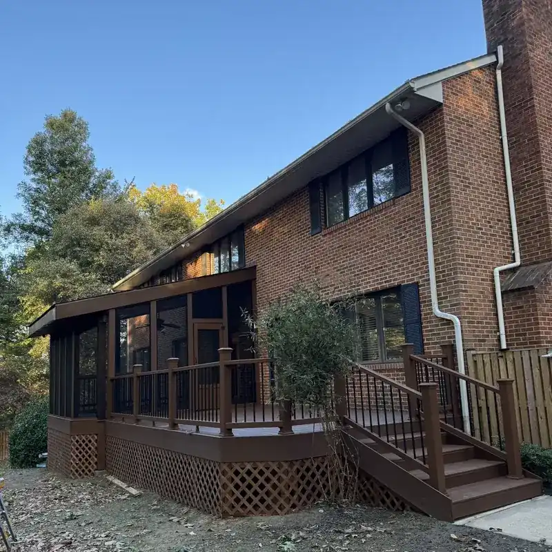 brick house with screened porch and brown deck