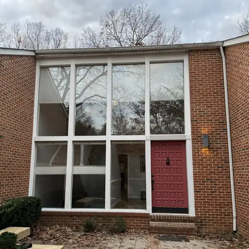 brick building with large window wall and red door