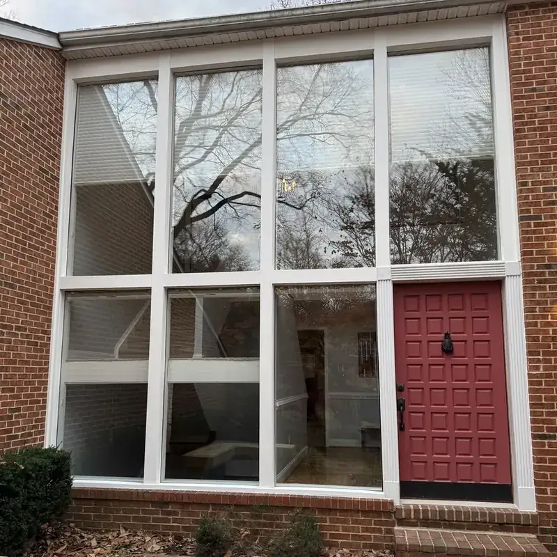 brick building with large window wall and red door