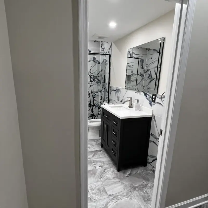 marble bathroom with dark vanity and mirror