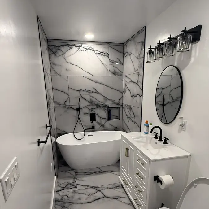 Bathroom with tub vanity round mirror marble tile