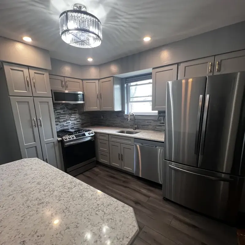 Gray kitchen with quartz island and stainless appliances