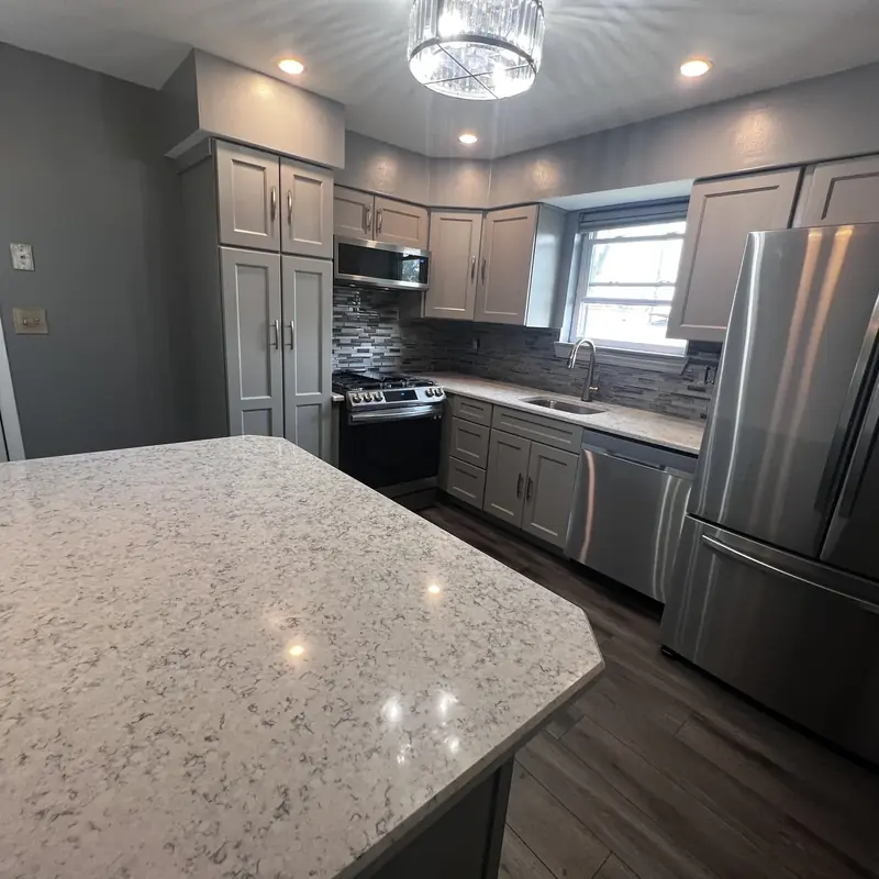 Kitchen island with light stone countertop gray cabinets