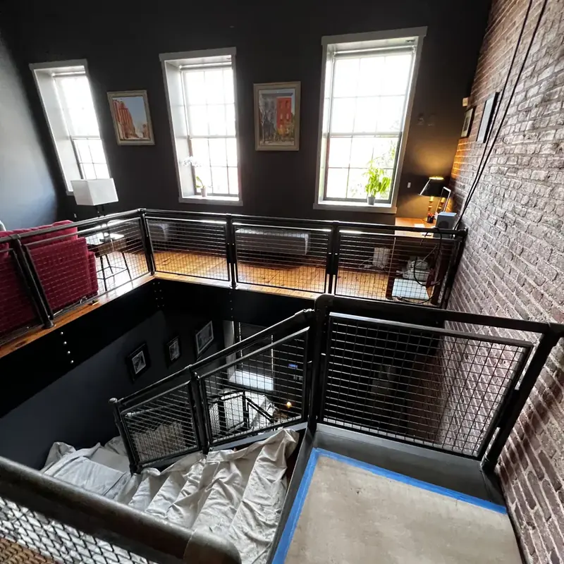 Loft staircase with metal railings brick wall windows