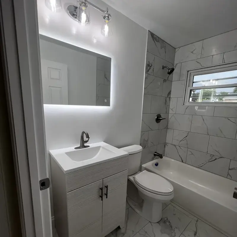 Bathroom with white vanity LED mirror tub and tile