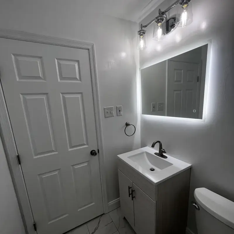Small bathroom with vanity LED mirror white door