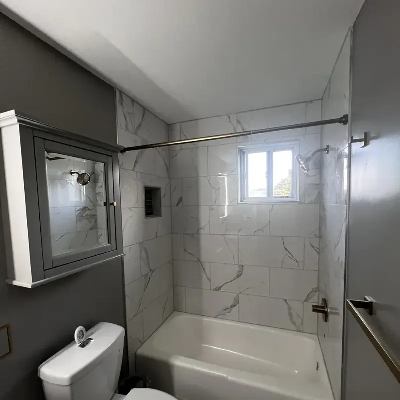 Tub with marble tile surround toilet medicine cabinet