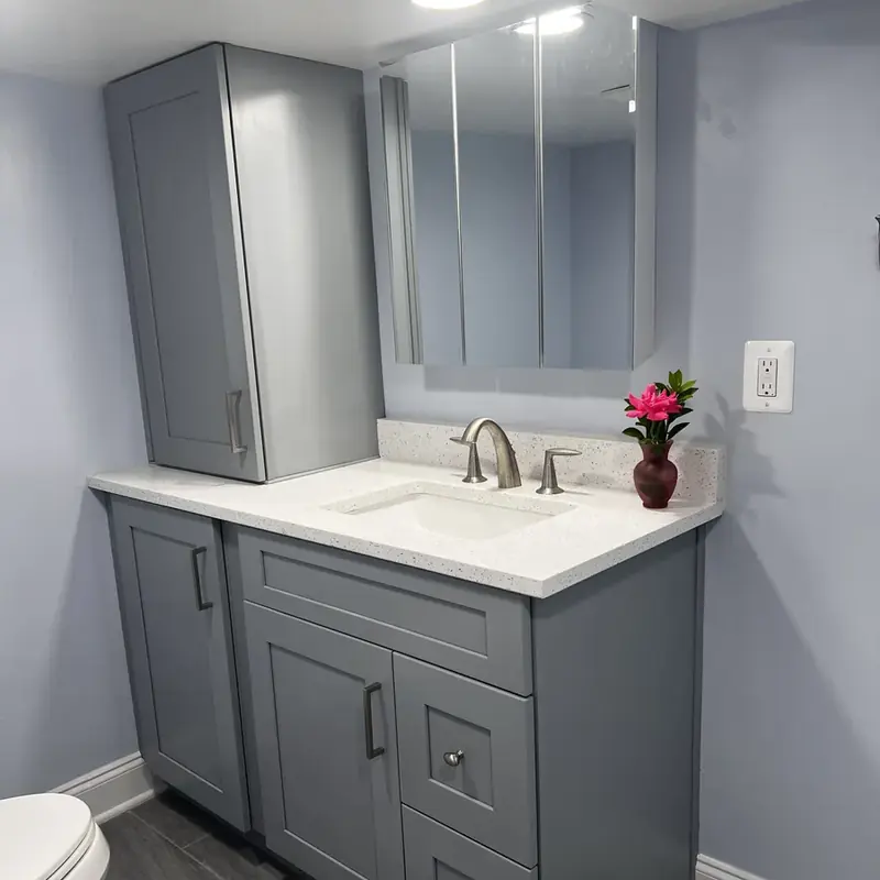 Gray vanity with white counter and flowers in vase