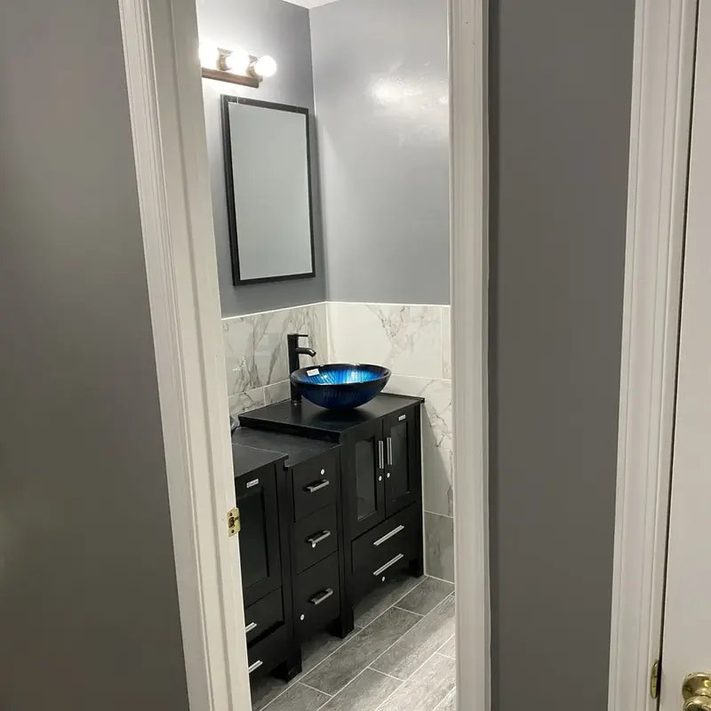 Black vanity with blue glass vessel sink