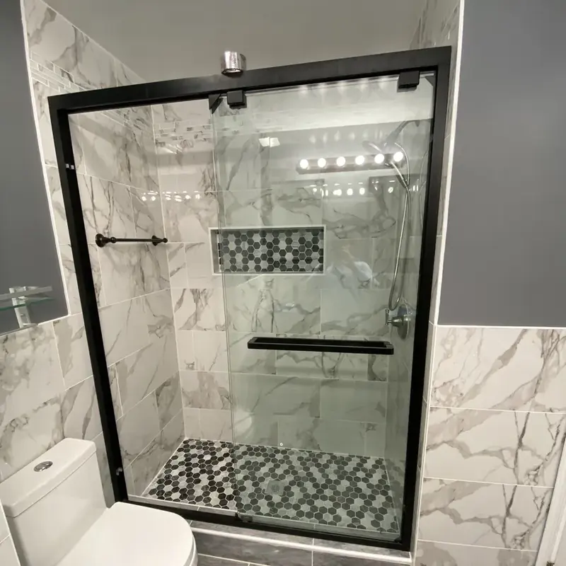 Walk-in shower with marble tile and mosaic accent
