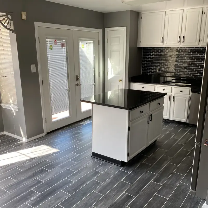 Kitchen island with black countertop and gray floor