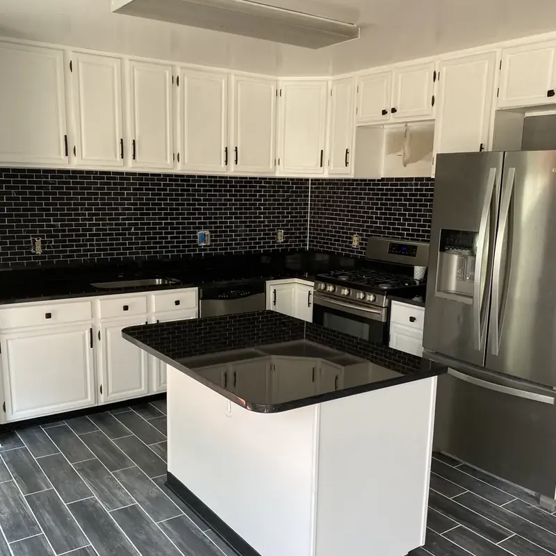 Kitchen with dark brick backsplash and black granite counters