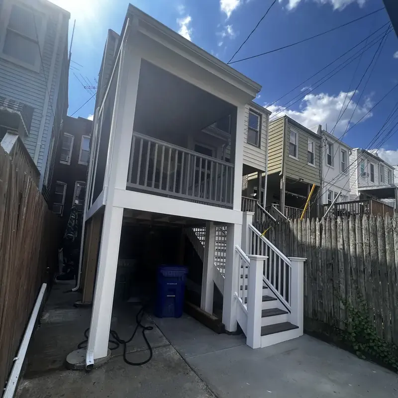 Exterior raised deck with white stairs between row houses