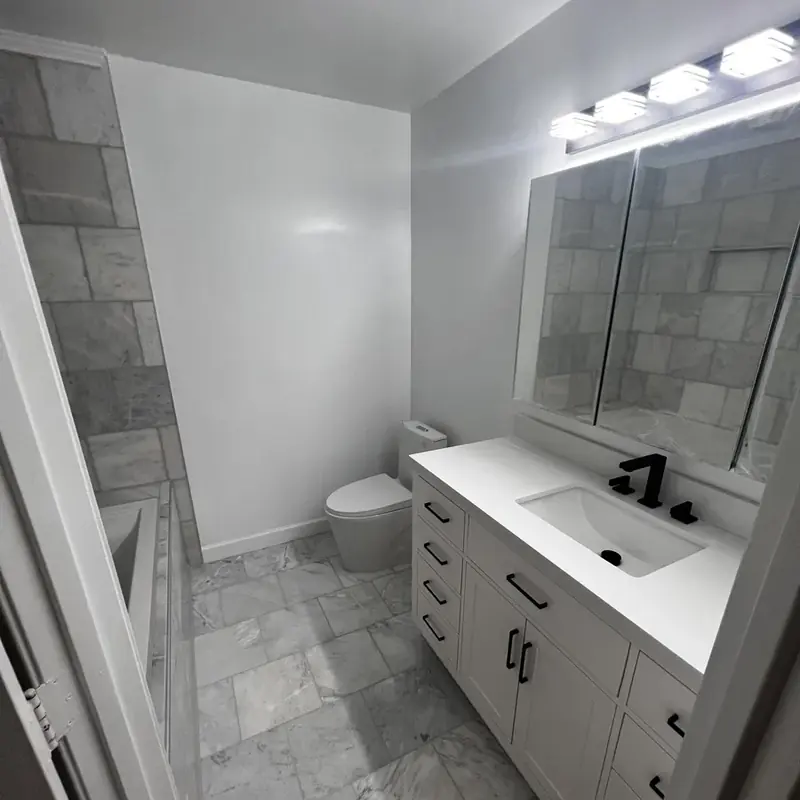 Bathroom with white vanity, toilet, and marble floor
