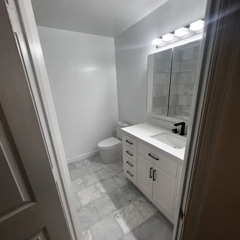 Compact bathroom with white vanity and toilet