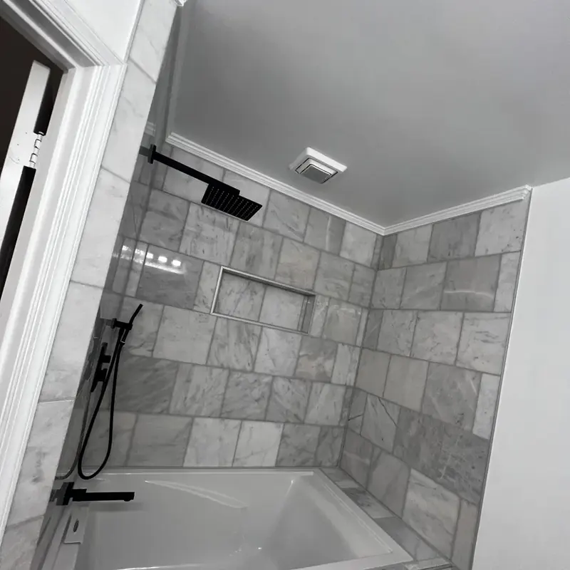 Tub-shower with marble tile and black hardware