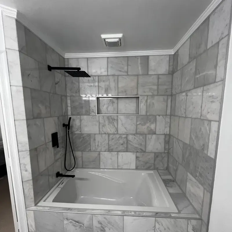 Marble tiled tub surround with niche and shower