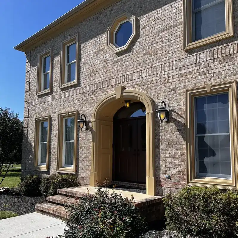 Brick home entrance with arched doorway and lanterns