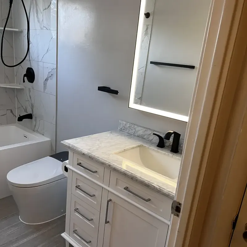 White vanity with LED mirror and marble countertop