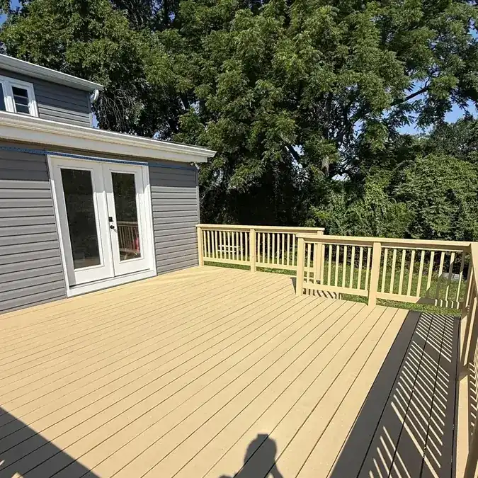 Finished tan composite deck with railings and backyard views