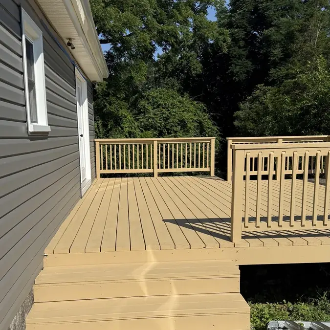 Finished composite deck with steps and railings on a remodeled home
