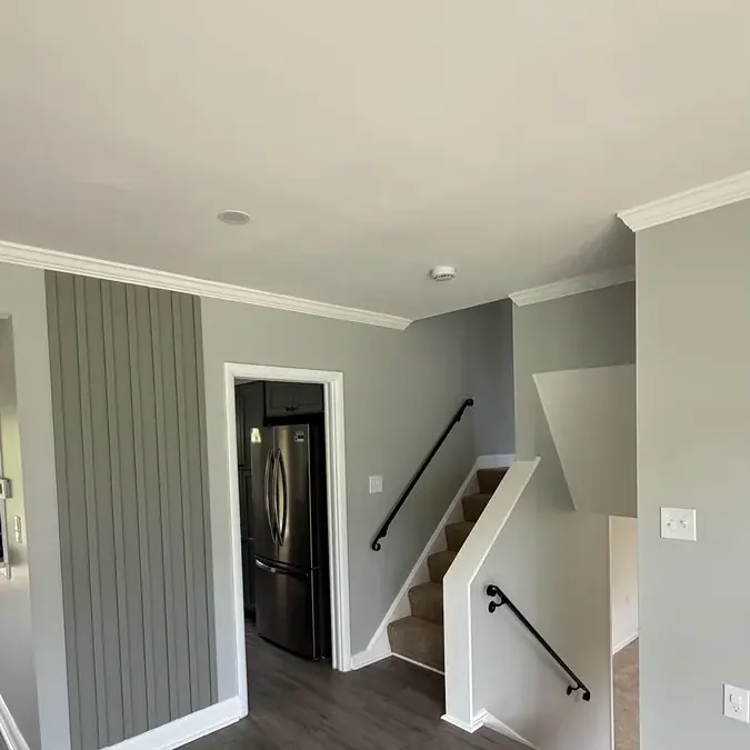 Interior remodel with fresh paint, board-and-batten accent wall, and refinished staircase